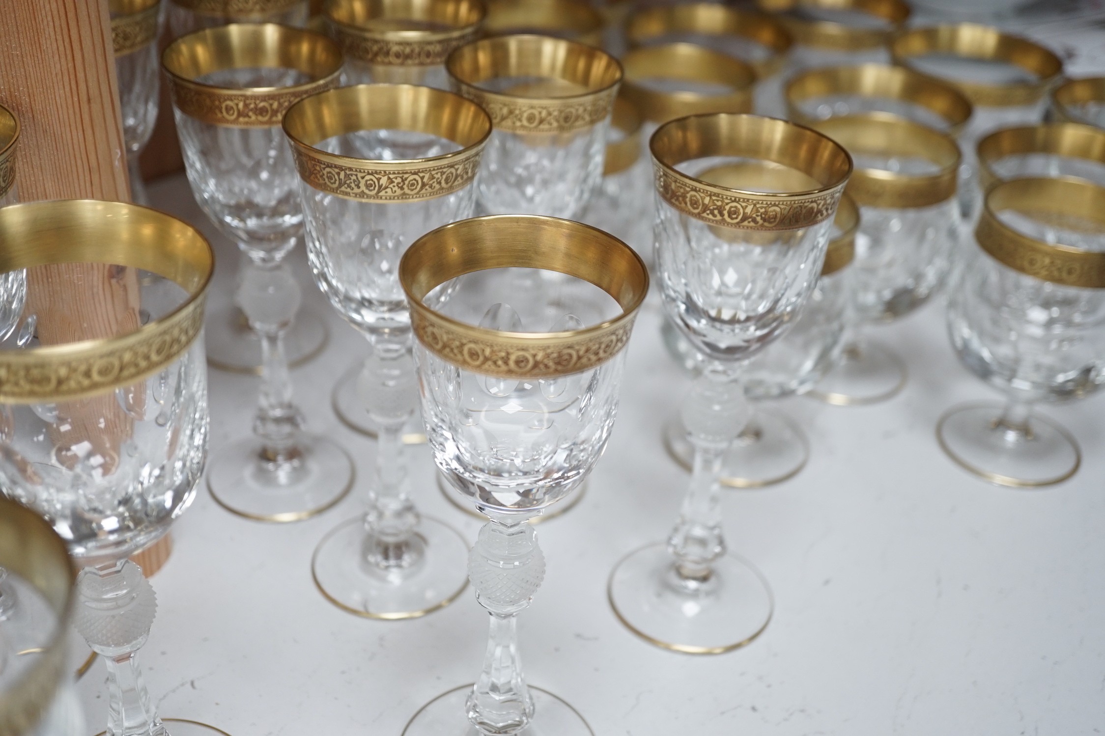 A Harrods retailed parcel gilt and cut and moulded suite of drinking glasses, two decanters and two carafes